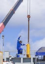 Asian engineer with crane truck transferring yellow hydraulic cylinder into sand suction dredger ship at harbor Royalty Free Stock Photo