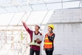 Asian engineer foreman worker man and woman working at building construction site use laptop and talking with radio Royalty Free Stock Photo