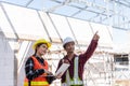 Asian engineer foreman worker man and woman working at building construction site use laptop and talking with radio Royalty Free Stock Photo