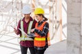 Asian engineer foreman worker man and woman working at building construction site use laptop and talking with radio Royalty Free Stock Photo