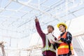 Asian engineer foreman worker man and woman working at building construction site use laptop and talking with radio Royalty Free Stock Photo