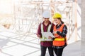 Asian engineer foreman worker man and woman working at building construction site use laptop and talking with radio Royalty Free Stock Photo