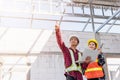 Asian engineer foreman worker man and woman working at building construction site use laptop and talking with radio Royalty Free Stock Photo