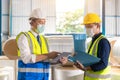 Asian engineer foreman working check list with staff worker in warehouse factory