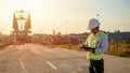 Asian engineer with hardhat using tablet pc computer inspecting and working at construction site Royalty Free Stock Photo