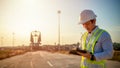 Asian engineer with hardhat using tablet pc computer inspecting and working at construction site Royalty Free Stock Photo