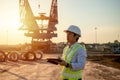 Asian engineer with hardhat using tablet pc computer inspecting and working at construction site Royalty Free Stock Photo