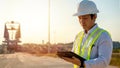 Asian engineer with hardhat using tablet pc computer inspecting and working at construction site Royalty Free Stock Photo