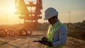 Asian engineer with hardhat using tablet pc computer inspecting and working at construction site Royalty Free Stock Photo