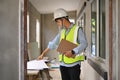 Asian engineer man planning development details, examining plans at construction site. Engineer, construction concept Royalty Free Stock Photo