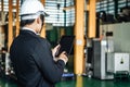 Asian engineer man wearing white helmet and using tablet to monitoring the production status Royalty Free Stock Photo