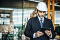 Asian engineer man wearing white helmet and using tablet to monitoring the production status Royalty Free Stock Photo