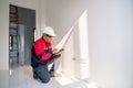 Asian engineer or senior specialist checking electrical outlets in a new unfinished residential house