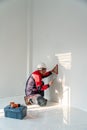 Asian engineer or senior specialist checking electrical outlets in a new unfinished residential house at construction site.