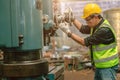 Asian engineer technician worker wearing safety suit helmet eyes protection focus manual skill control machine production process Royalty Free Stock Photo