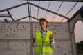 Asian engineer in uniform and helmet at construction site being happy and smiling for success. Royalty Free Stock Photo