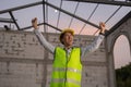 Asian engineer in uniform and helmet at construction site being happy and smiling for success. Royalty Free Stock Photo