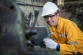 Asian engineer wearing yellow work clothes white hardhat and wear glove looking.