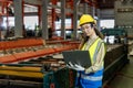 Asian engineer worker inspecting inside the steel manufacturing factory while looking at the laptop for monitoring the improvement Royalty Free Stock Photo