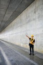 Asian engineering worker wearing hard hat and protective vest using a tablet he standing and points his finger to side. Royalty Free Stock Photo