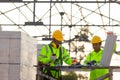 Asian engineers and consultant workers calculate the amount of bricks used in construction, Concept of construction team work