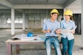Asian engineers couple working together on building blueprint at construction site or factory. Construction engineering concept Royalty Free Stock Photo