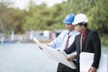 Asian engineers were consulted together and plan with blueprint in construction site Royalty Free Stock Photo