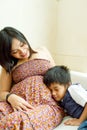 Asian ethnic pregnant mother and son