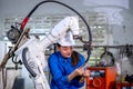 Asian factory worker woman hold tablet and maintenance with check part of robotic machine in workplace area. Industrial and Royalty Free Stock Photo