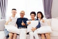 Asian family with adult children and senior parents giving thumbs up and relaxing on a sofa at home together. Royalty Free Stock Photo