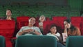 An Asian family audience enjoys watching cinema together at movie theaters.