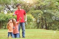 Asian family are blowing soap bubbles together. Royalty Free Stock Photo