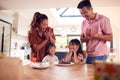 Asian Family Celebrating Daughters Birthday At Home Surprising Him With Candle Covered Cake