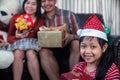 Asian family in Christmas interior.Happy daughter mother and father holding a gift box with smile Royalty Free Stock Photo