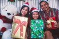 Asian family in Christmas interior.Happy mother father and  daughter holding a gift box with smile Royalty Free Stock Photo