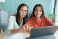 Asian family with a daughter do homework by using tablet with mother help. Happy smile Asia kid while sitting in the living room Royalty Free Stock Photo