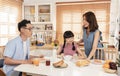 Asian family enjoy eating breakfast together in kitchen room at home Royalty Free Stock Photo