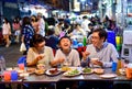 Asian family enjoy eating food on street food restaurant with crowd of people at Yaowarat road, Bangkok Royalty Free Stock Photo