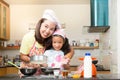 Asian family enjoy making pancake, Asian mother and daughter enjoy making bakery cake, Little Asian girl and mom enjoy decorate p