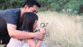 Asian family father and daughter exploring nature with magnifying glass.16:9 style Royalty Free Stock Photo
