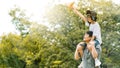 Asian family Father and son sat on his shoulders and run in the park.