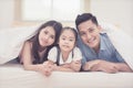 Asian family happy smiling and relax on bed at home.