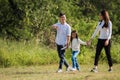 Asian family having fun and enjoying outdoor walking down the road outside together in the park Royalty Free Stock Photo