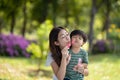 Asian family having fun mother and her son playing with soap bubbles in the park together Royalty Free Stock Photo