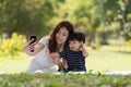 Asian family having fun mother and her son taking selfie with mobile phone in the park together, love and happiness people concept Royalty Free Stock Photo