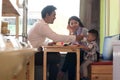 Happy asian family, with one todler spending time together inside bakery store and cafe eating cake Royalty Free Stock Photo