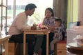 Happy asian family, with one todler spending time together inside bakery store and cafe eating cake Royalty Free Stock Photo