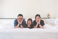 Asian Family Lovely lie about puckering lips and Pose hands on chin on white bed