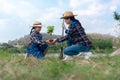 Asian family mom and kid daughter plant sapling tree outdoors in nature spring for reduce globa Royalty Free Stock Photo