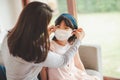 mother puts on mask for her daughter face for protection from Coronavirus